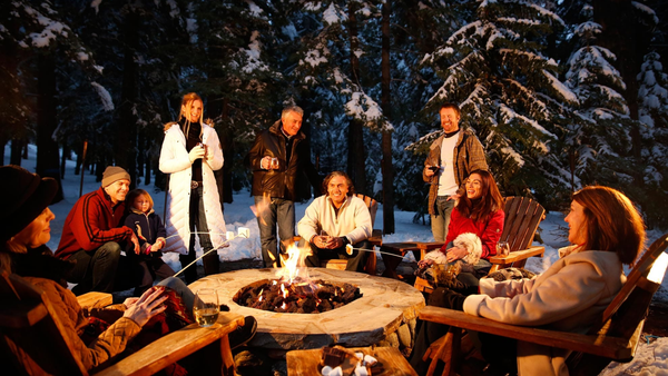 group of friends roasting marshmallows in a fire pit winter decor