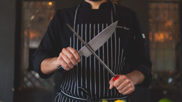 man hands sharpening a kitchen knife